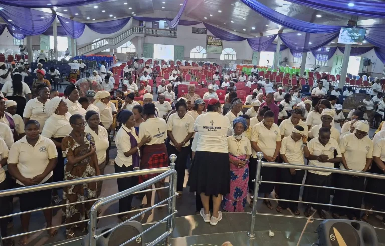 Bishop Dr. Julien O. Gbakara leading women in prayer